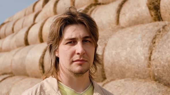 Portrait of Caucasian Young Man Farmer Agronomist on Hay Bales Background on the Wheat Field After alt