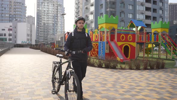 Deliveryman Carrying Bike Through City Courtyard