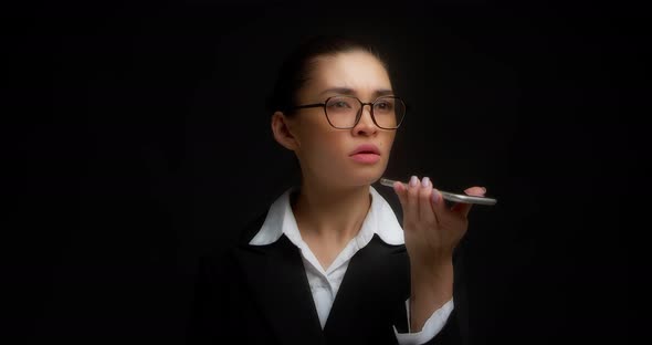 Business Woman Listens to an Voice Message on Her Smartphone alt