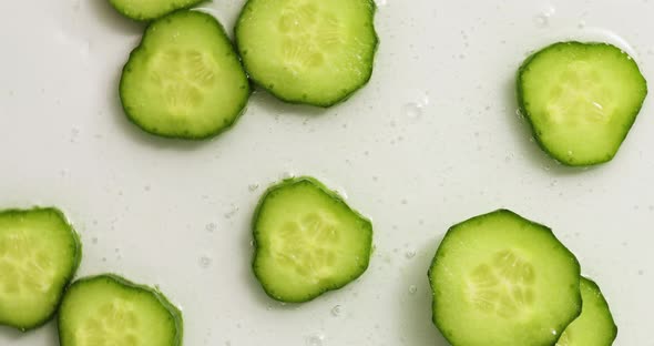 Rotation cucumber slices with gel on white background