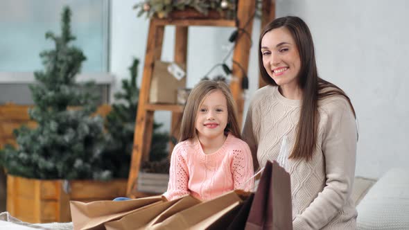 Laughing Young Beautiful Woman Pose with Female Little Child Having Xmas Paper Shopping Bag alt