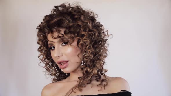 Sexy Young Woman with Curly Hair Looking at Camera