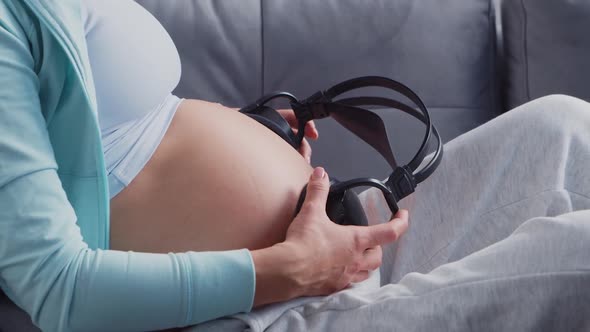 Young pregnant woman is resting at home and expecting a baby. alt