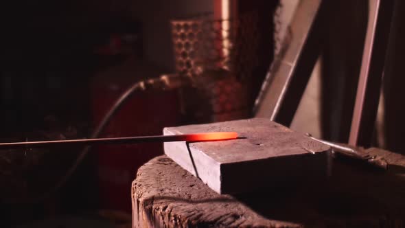 Blacksmith Hitting Hot Metal Bar with Massive Hammer on Anvil in Slow Motion