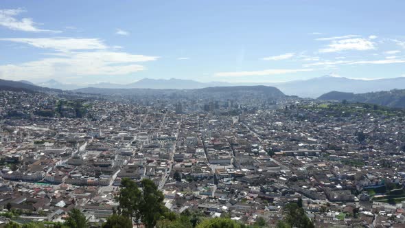 Aerial view of a cityscape, showing the highrise and the entire city of Quito