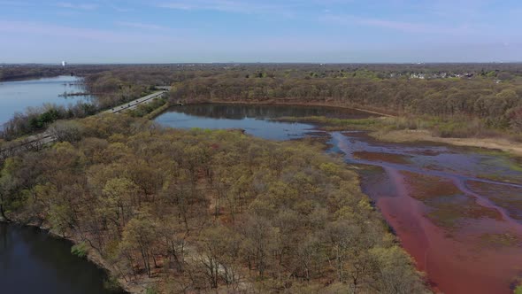 An aerial view of some reflective lakes during the day. The drone pan left, dolly in then tilts down alt