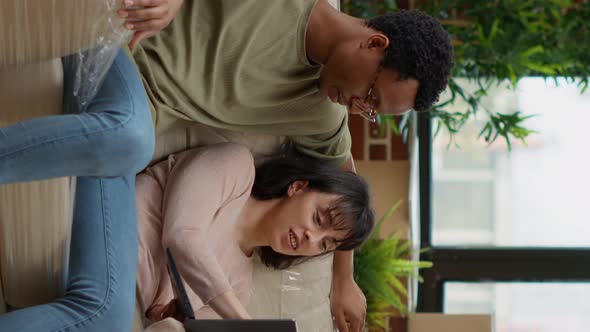 Vertical Video Diverse Couple Browsing Internet to Buy Decor on Laptop alt