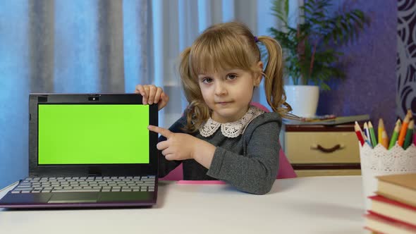 Child Girl with Laptop Looking on Green Screen at Home Online Distance Lessons Children Education alt
