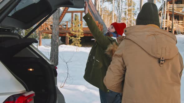 Family Arriving at Cozy Cabin in Winter alt