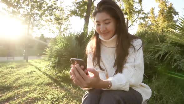 Closeup of Beautiful Young Business Asian Woman with Smartphone Texting Messenger with Skyscrapers