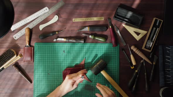Craftman Knocking Making Holes in Brown Leather Using Professional Tools on Table at Leather alt