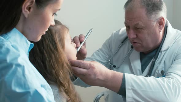 Male doctor examining little girl