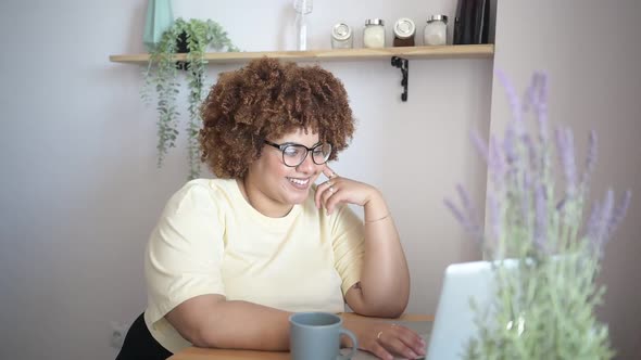 Attractive Happy Stylish Plus Size African Black Woman Student Afro Hair in Glasses Studying Online