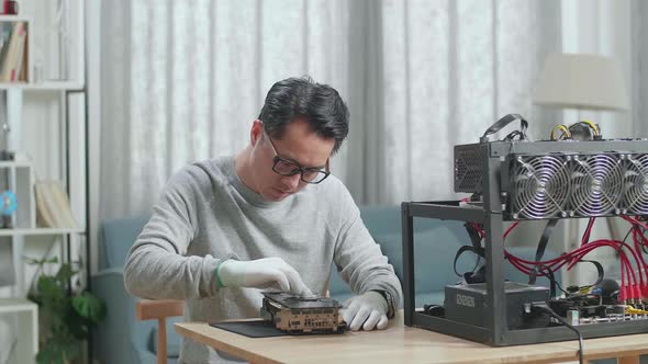 Asian Man Wearing Glasses Wiping The Mining Rig For Mining Cryptocurrency alt