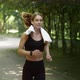 Sporty Middle Aged Woman Athlete in Earbuds Running in Public Park with Towel on Shoulders Follow - VideoHive Item for Sale