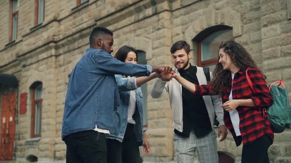 Slow Motion of Multiracial Group of Friends Travelers Putting Palms Together Then Raising Arms in alt