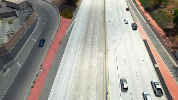 Route 134 freeway in Burbank, California with light traffic during daytime - tilt up aerial reveal alt
