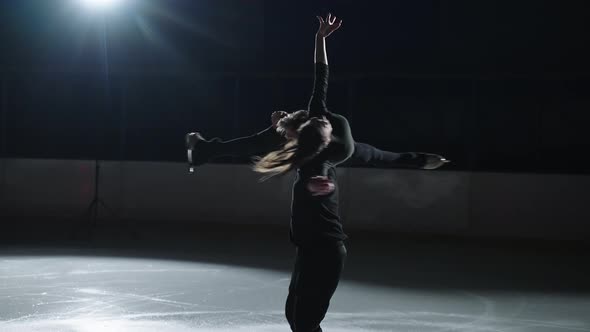 Slow Motion Young Couple of Artistic Figure Skaters is Performing a Pair Skating Choreography on Ice alt