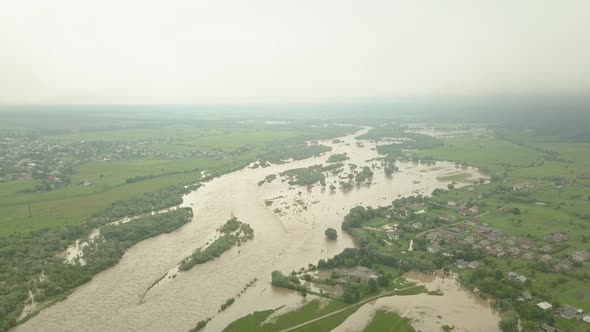 Aerial View of the Overflowing River. Drone in the Clouds. Extremely High Water Level in the River