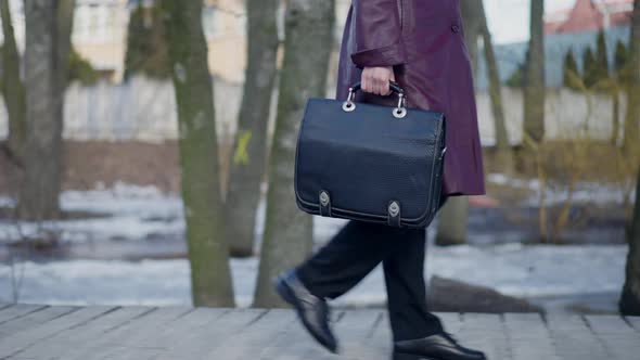 Side View Tracking Shot of Unrecognizable Female Private Investigator with Black Handbag Strolling alt