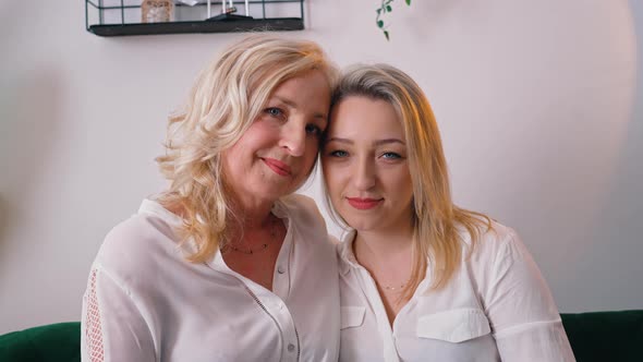 Two Blonde Women Looking Alike Wearing Snowwhite Elegant Shirts Looking Directly at a Camera alt
