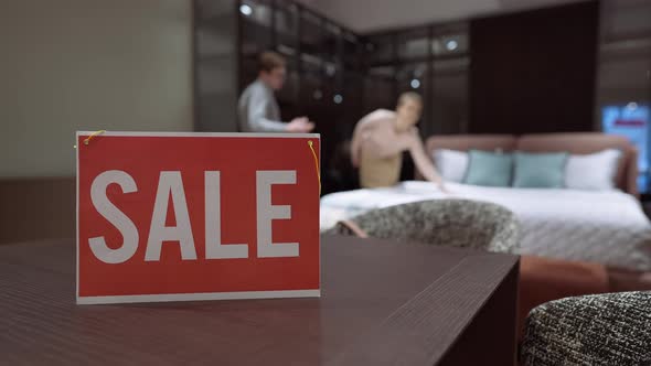 Sale Message on Table in Furniture Store with Blurred Buyer and Seller Talking Discussing alt