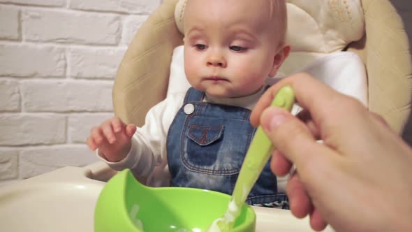 Baby is Waiting for Start of Feeding Without Waiting Dips His Fingers in Food