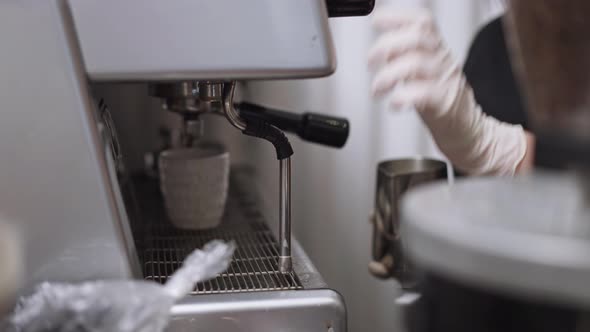 Unrecognizable Barista Steaming Milk Using Coffee Machine in Cafe Restaurant Indoors alt