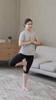 Young Indian Woman Meditating Standing on Carpet and hand Namaste, Doing balance