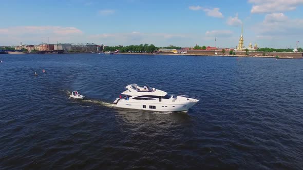 Small Speed Boat And Luxury Yacht In A City River