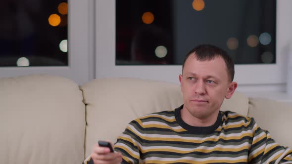 Young man watching a funny movie, smiling, positive emotions, relaxation concept, copy space alt