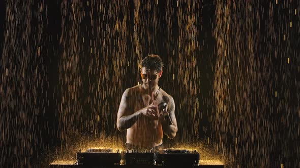 Semi Nude Wet Disc Jockey Performing at a Mixer Controller, Spotted By Yellow Lights on Black alt