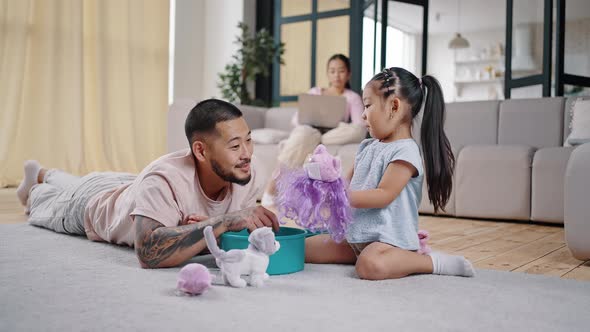 Father and Daughter Play with Toys Sitting on Cozy Carpet alt