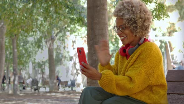 Latin American Woman Making a Video Call with Mobile Phone in the Park alt