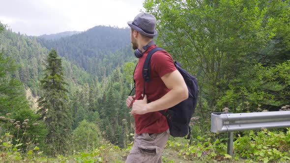 Tourist walking on the road in the forest. alt