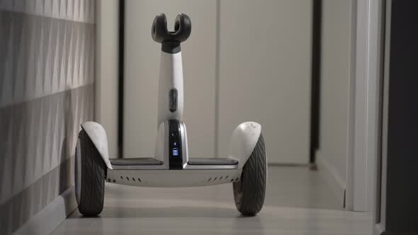 White Modern Gyro Scooter Gadget Balances Itself and Spins Without Intelligence in the Room and Hits alt