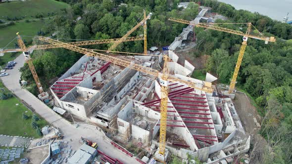 Aerial View Construction of a New Building with High Tower Cranes in Green Area alt
