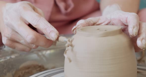 Female Potter Sitting and Makes a Cup on the Pottery Wheel. Woman Making Ceramic Item alt