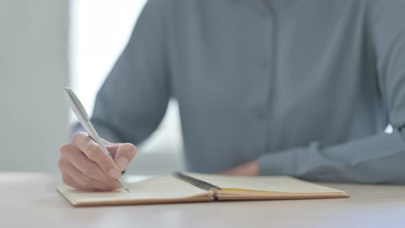 Close Up of Woman Writing on Notebook alt