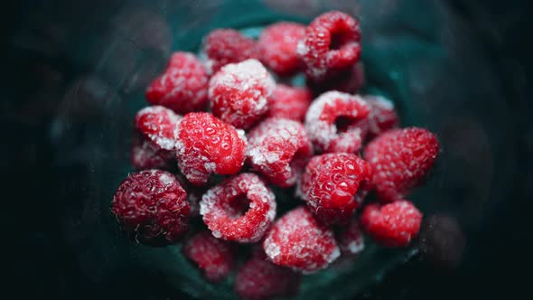 A Pile of Frozen Raspberries is Quickly Frosting in a Glass alt