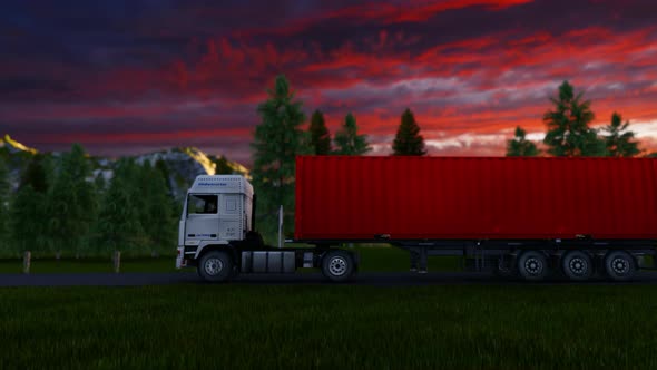 Aerial View Of a Semi-Trailer Truck Driving Along A Countryside Road In To The Sunset