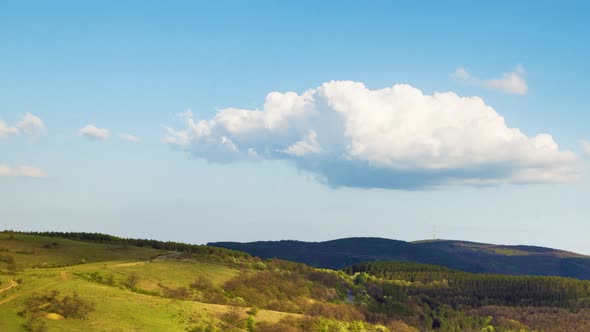 Valley with Meadows on Which Bushes and Trees Grow and the Balkan Mountains Under the Sky alt