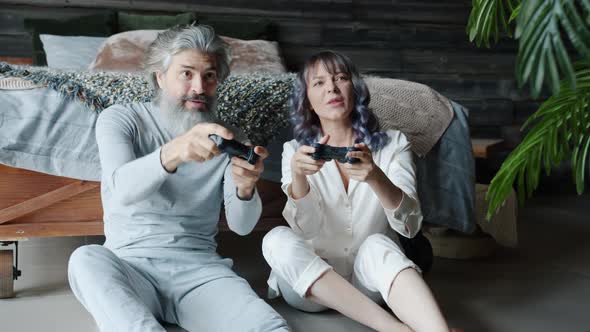Man and Woman Enjoying Video Game Playing Then Doing Highfive and Laughing in Bedroom alt