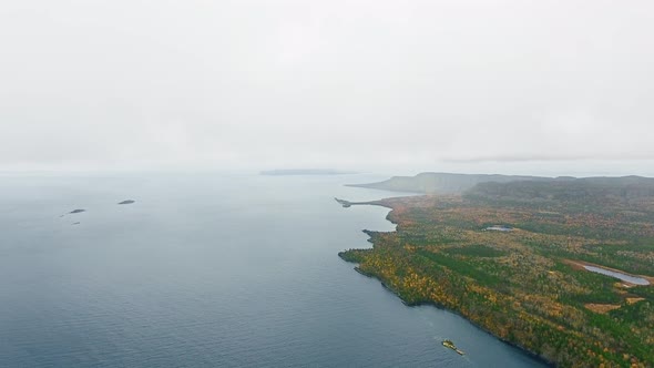 Aerial camera shoots a horizon above a lake and coast in Lake Superior, Great Lakes, Ontario, Canada alt