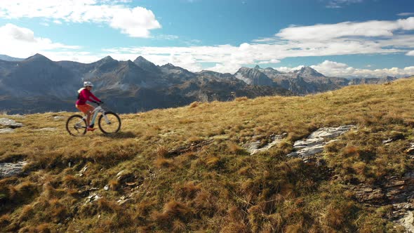 Aerial View Woman Mountain Biking on Ridge Side View alt