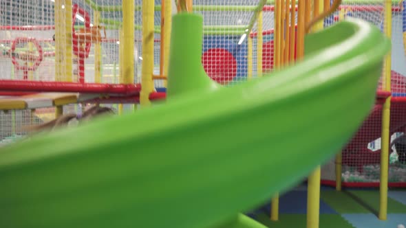 Girl Moving Down on Slide in Children's Play Center