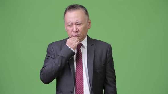 Mature Japanese Businessman Having Headache alt