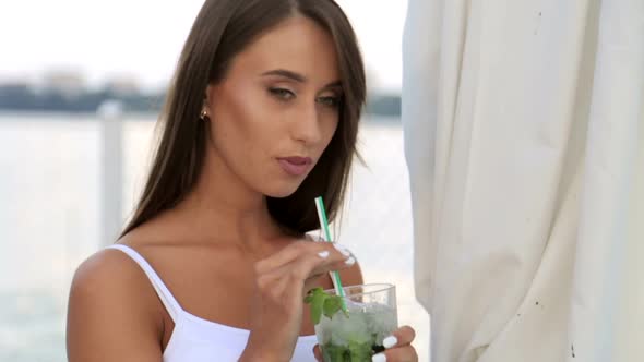 Young Beautiful Stylish Girl Drinks a Cocktail Beautiful Brunette alt