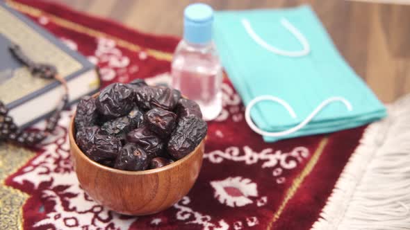 Holy Book Quran Date Fruit  Mask Hand Sanitizer and Rosary on Floor alt