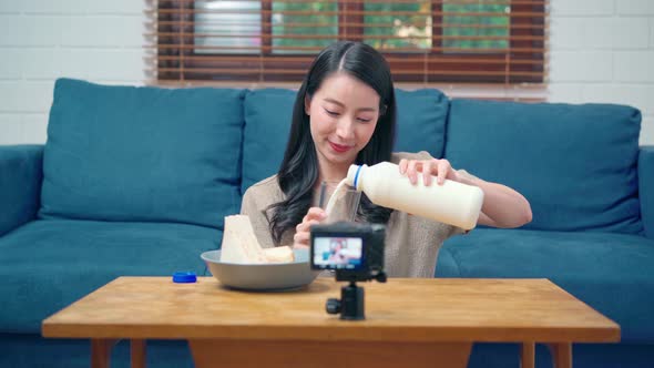 Asian women using camera streaming and recording vlog video about the benefit for broadcast online. alt